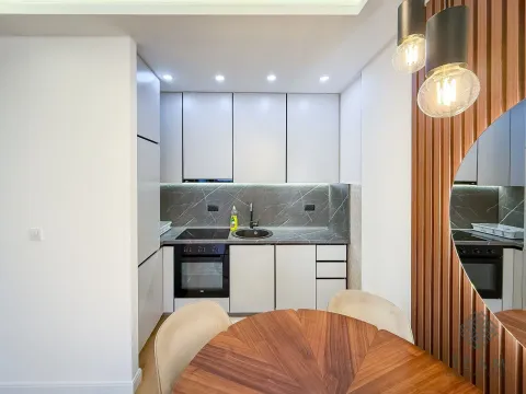 Modern kitchen with built-in appliances and a dining table. - image 5