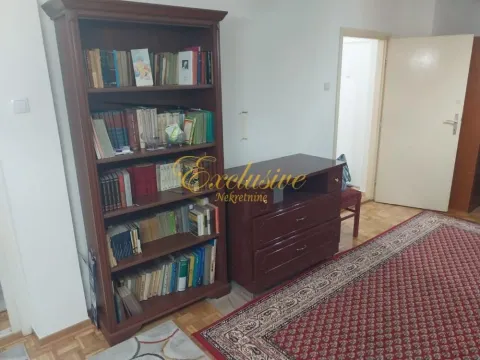 Dnevna soba sa velikom drvenom bibliotekom i komodom. - image 12