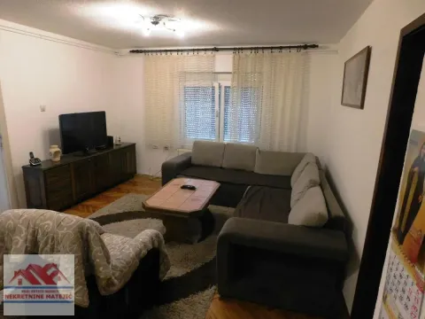 Dnevna soba sa garniturom, televizorom i prozorom sa zavesama. - image 19
