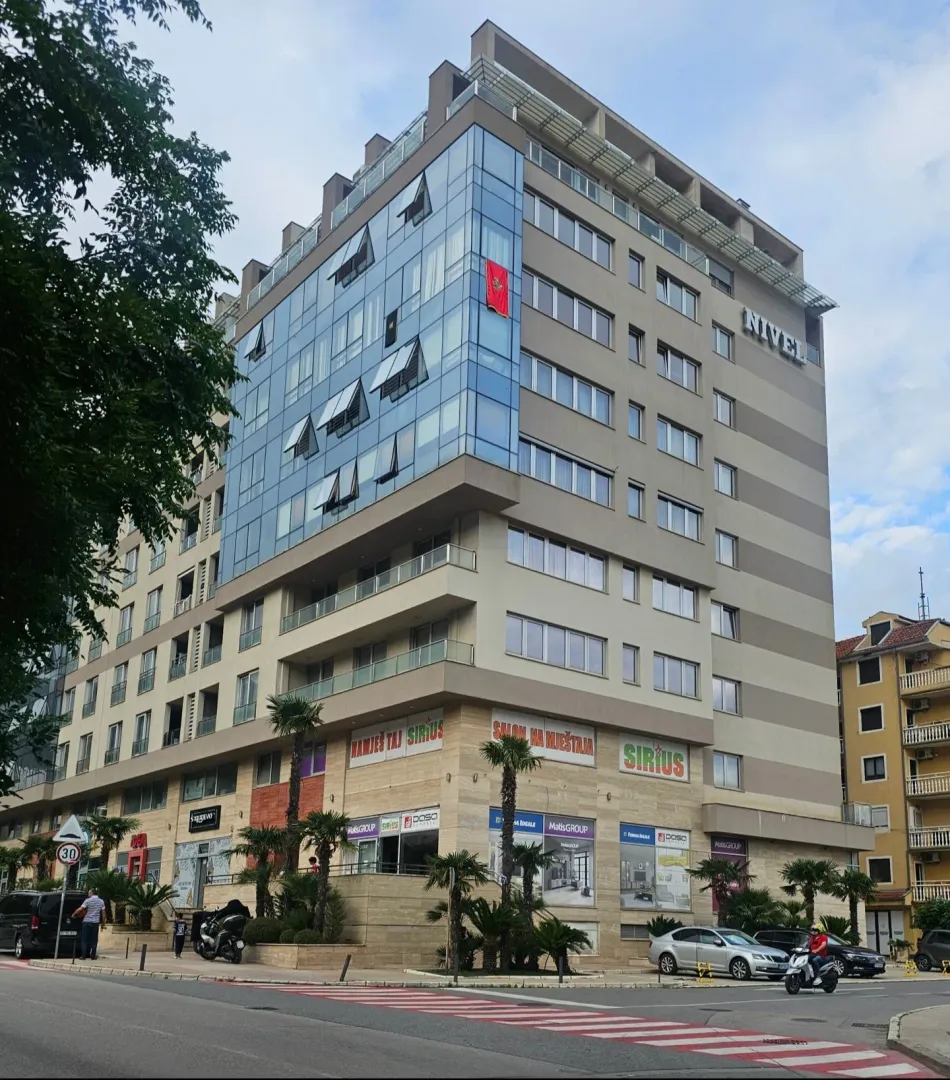 Exterior view of a modern commercial and residential building with retail space on the ground floor.