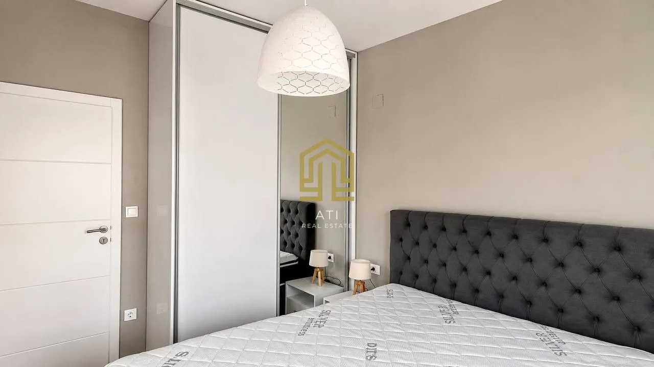 Bright bedroom with a modern bed and a built-in wardrobe.