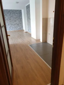 Empty unfurnished room with laminate and tile flooring. - image 5
