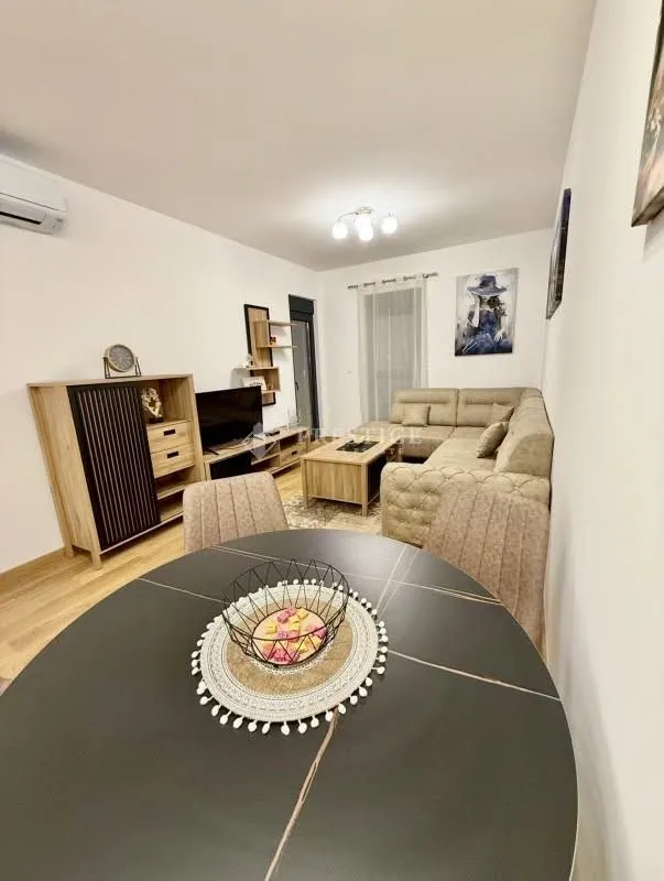 Spacious living room with a seating set and a dining table in the foreground.