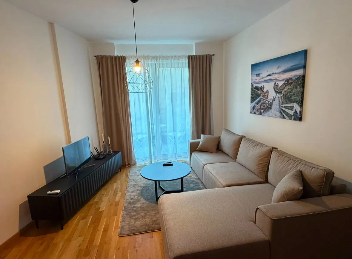 Living room with a sectional sofa, TV, and access to the terrace.