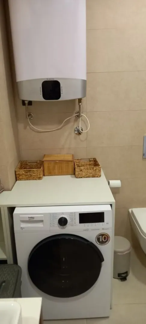 Bathroom with washing machine and water heater.