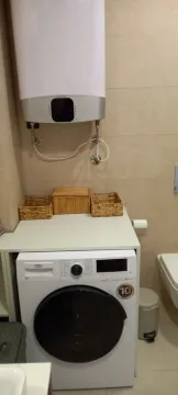 Bathroom with washing machine and water heater. - image 10