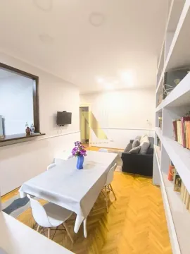 Dnevni boravak sa trpezarijskim stolom i policama za knjige. - image 6