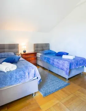 Bedroom with two single beds and a nightstand. - image 4