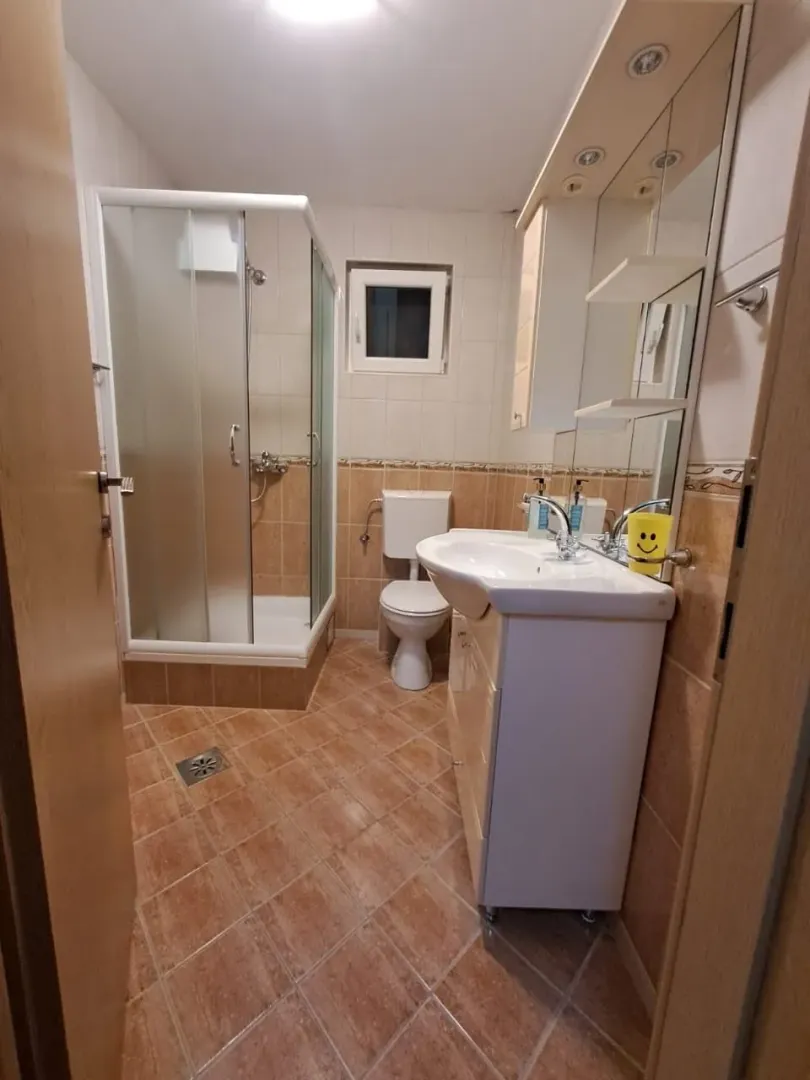 A tidy bathroom equipped with a shower cabin, sink, and toilet.