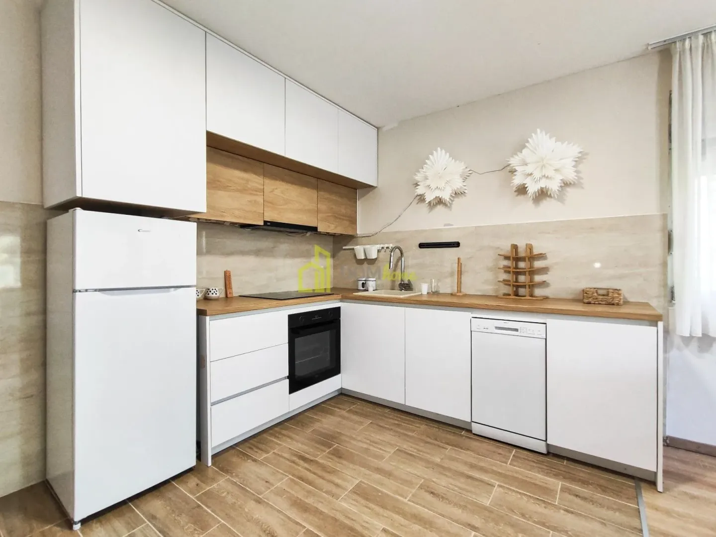 Modern kitchen with white cabinetry and wooden countertops.