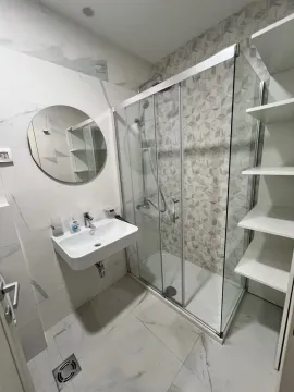 Modern bathroom with a walk-in shower, washbasin, and mirror. - image 12