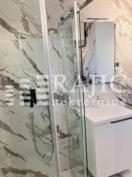Modern bathroom with a shower cabin and a sink. - image 9