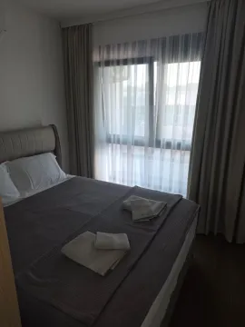 Uređena spavaća soba sa bračnim krevetom i prozorom sa zavjesama. - image 7