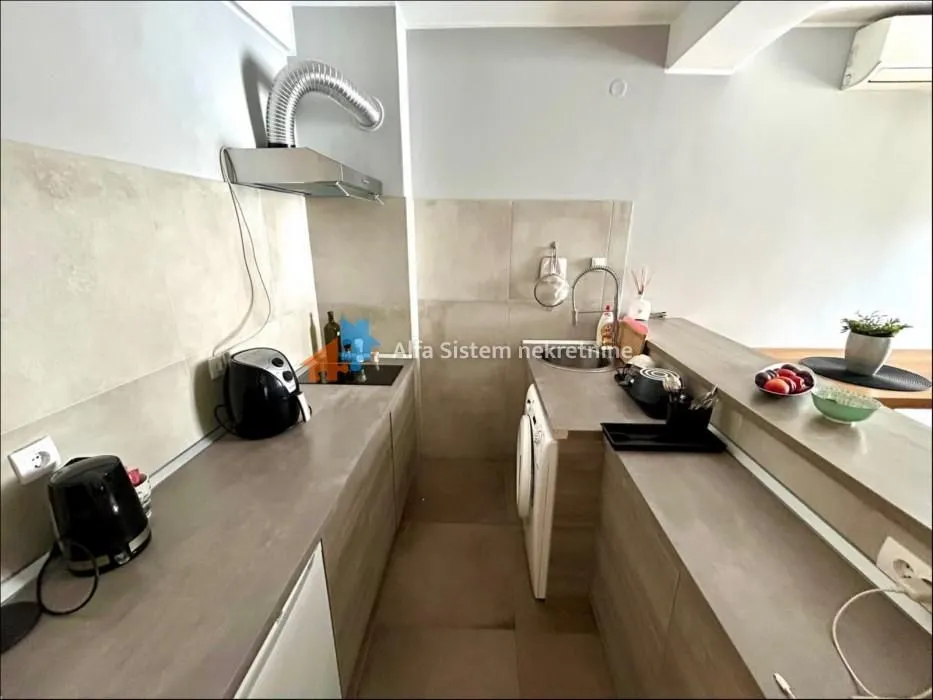 Small equipped kitchen with work units and a breakfast bar.