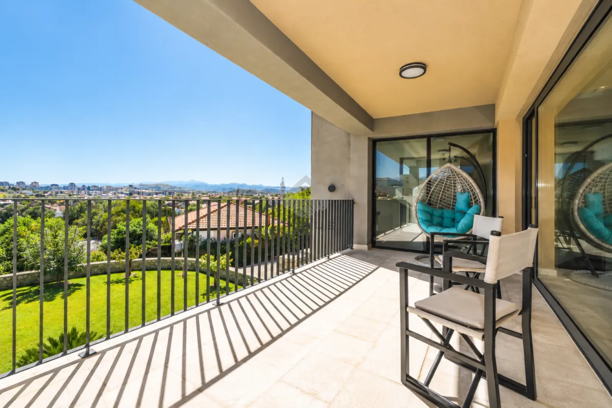 Spacious covered terrace with seating furniture and a view of the surroundings.