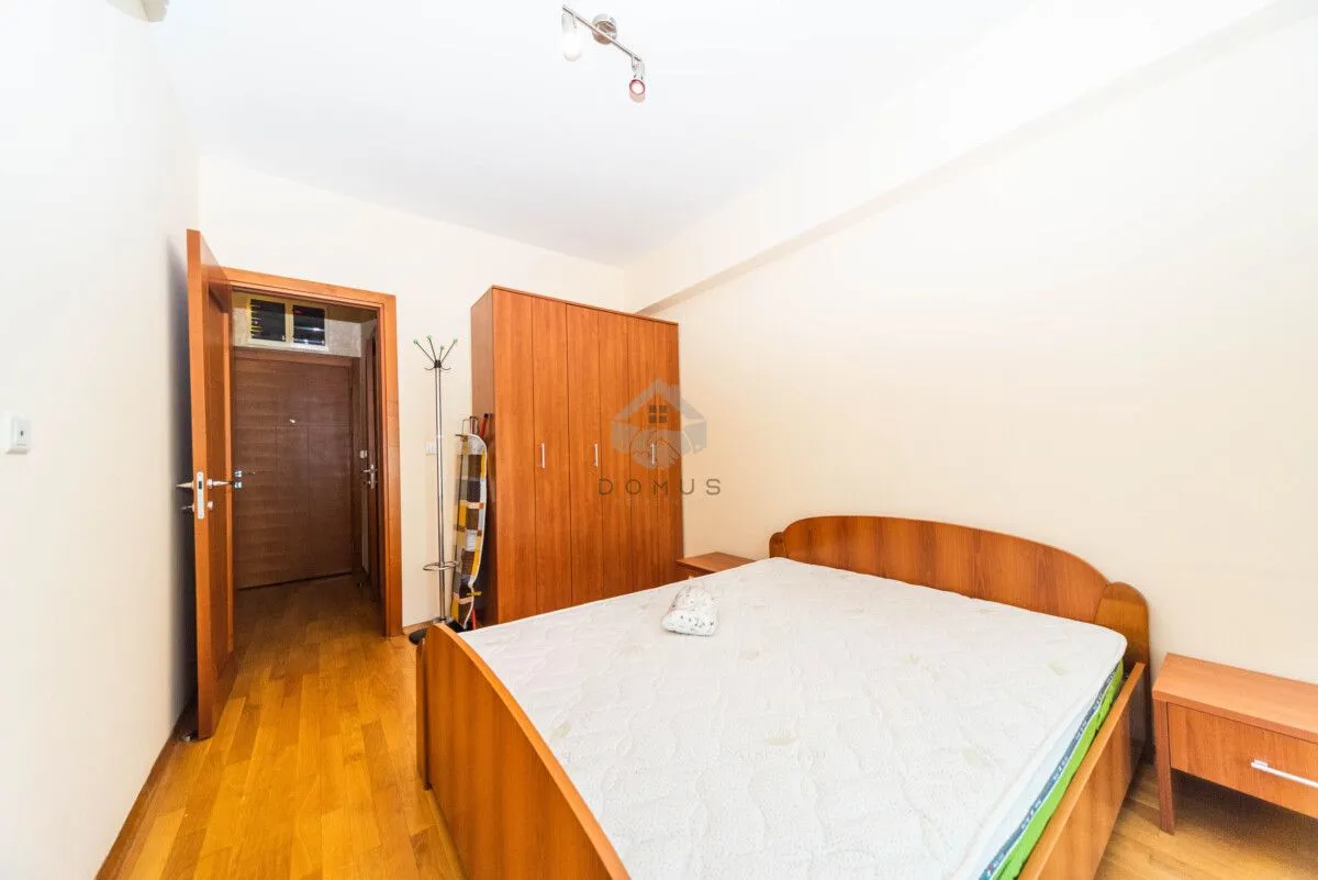 Bedroom with a double bed, wooden wardrobe and nightstands.