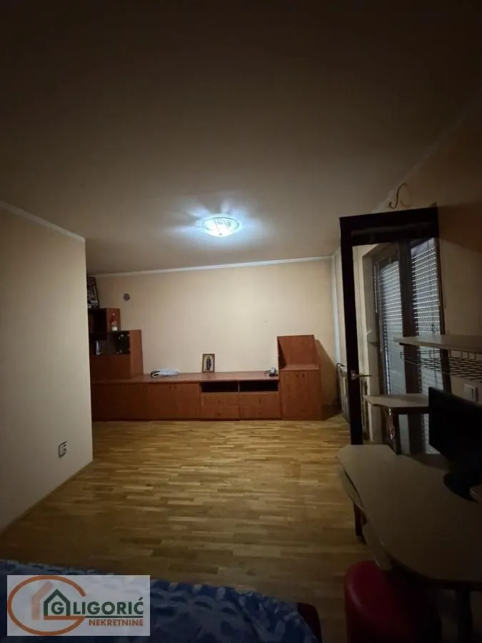 Living room with wooden furniture and parquet flooring.