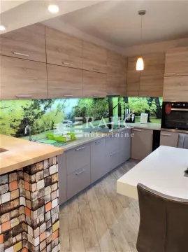 Modern kitchen with wooden elements and a dining table. - image 6