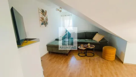 Living room with sofa, coffee table and television under a sloping roof. - image 5