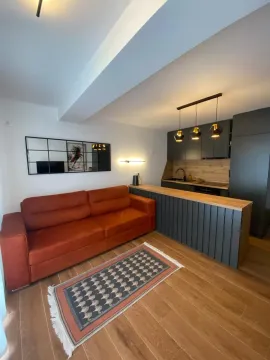 Modern living room with a sofa and a kitchen counter. - image 6