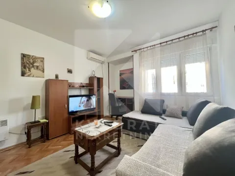 Furnished living room with a sofa, television and a small work corner. - image 2