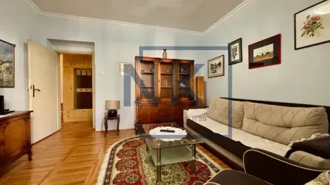 Living room with a sofa, a wooden display cabinet, and parquet flooring. - image 2