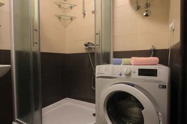 Kupatilo sa tuš kabinom i veš mašinom.
