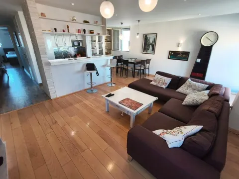 Living room with sofa set, dining area, and a breakfast bar connected to the kitchen. - image 9