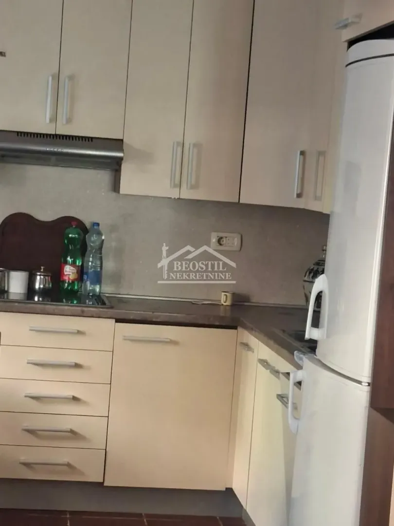 Compact kitchen with light-colored cabinetry and built-in appliances.