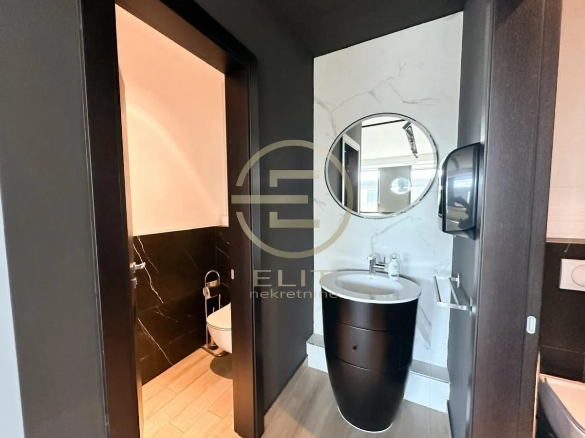 Modern bathroom with a washbasin and a round mirror.