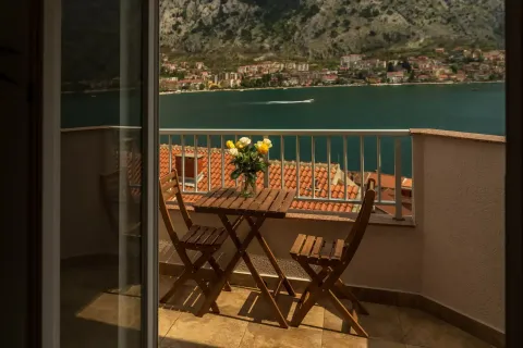Namješten balkon sa stolom, stolicama i pogledom na more. - image 2