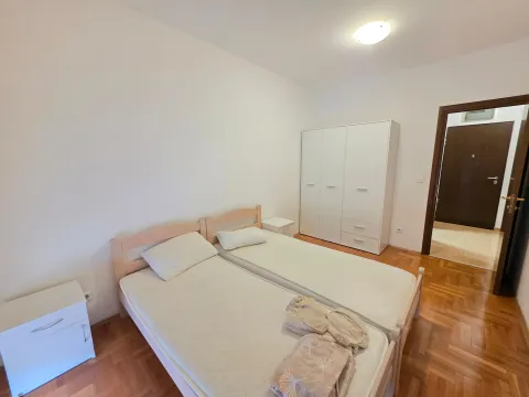 Bedroom with two single beds, white wardrobe, and parquet flooring. - image 8