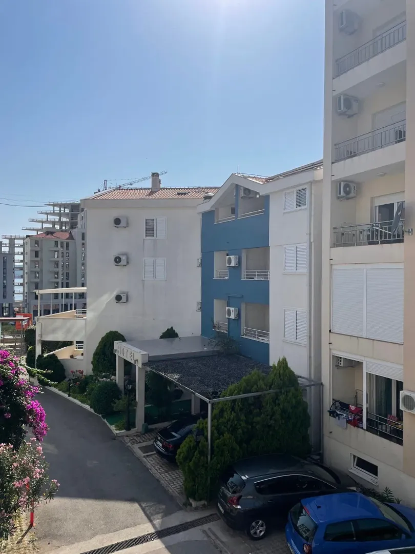 Pogled sa terase na spoljašnjost zgrade i parking.
