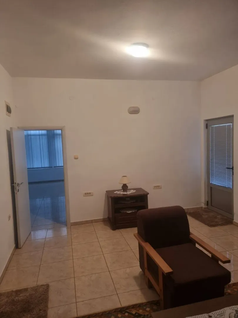 Dnevna soba sa foteljom i komodom.