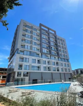 Exterior of a modern residential building with a courtyard swimming pool. - image 9