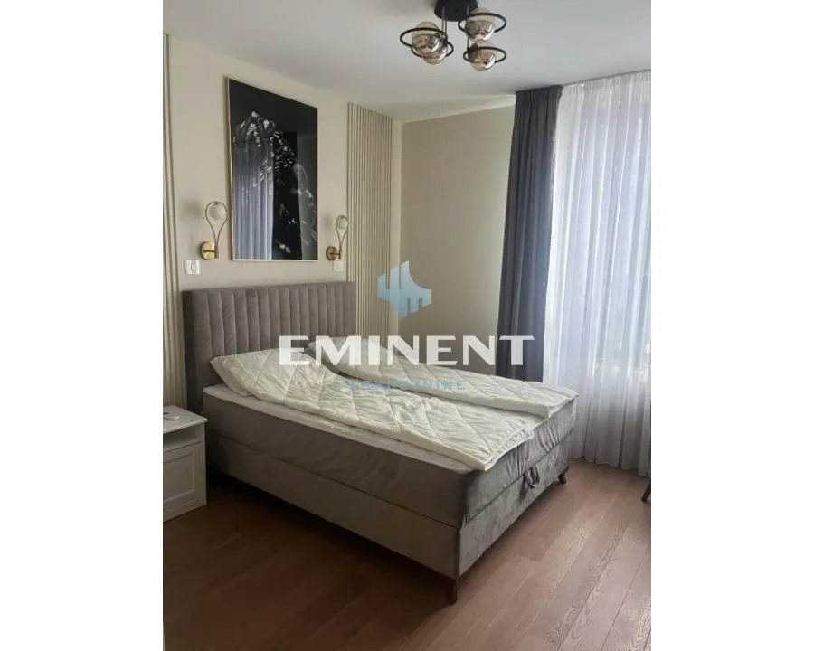Modern bedroom with a double bed and decorative lighting.