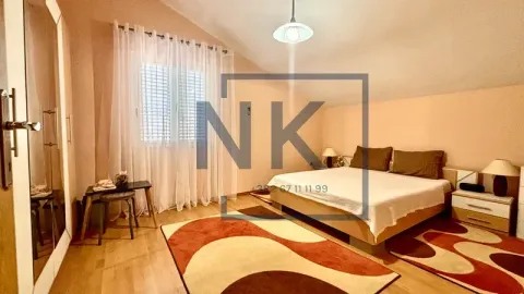 Spacious bedroom with a double bed, wardrobe, and a window covered with white curtains. - image 14