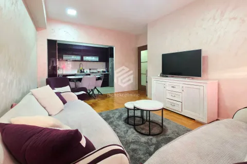 Dnevna soba sa garniturom, televizorom i pogledom na kuhinju u pozadini. - image 12