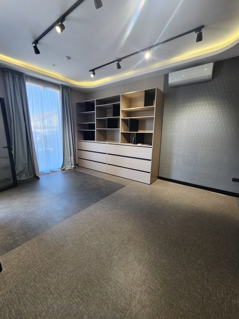 Empty room with a large built-in shelving unit and an air conditioner.