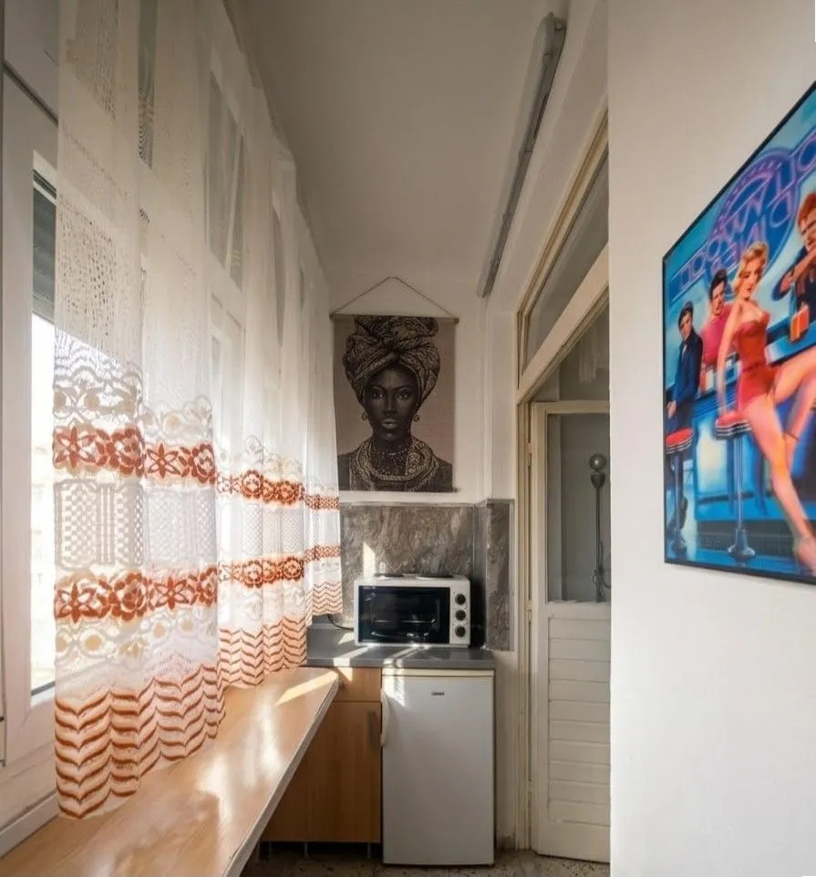 Small kitchen with a refrigerator and microwave next to the window.