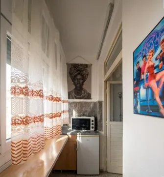 Small kitchen with a refrigerator and microwave next to the window. - image 2