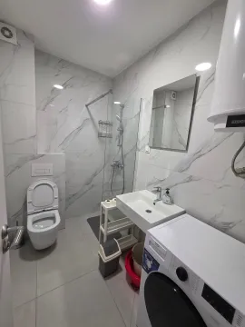Savremeno opremljeno kupatilo sa tuš kabinom, umivaonikom i veš mašinom. - image 8