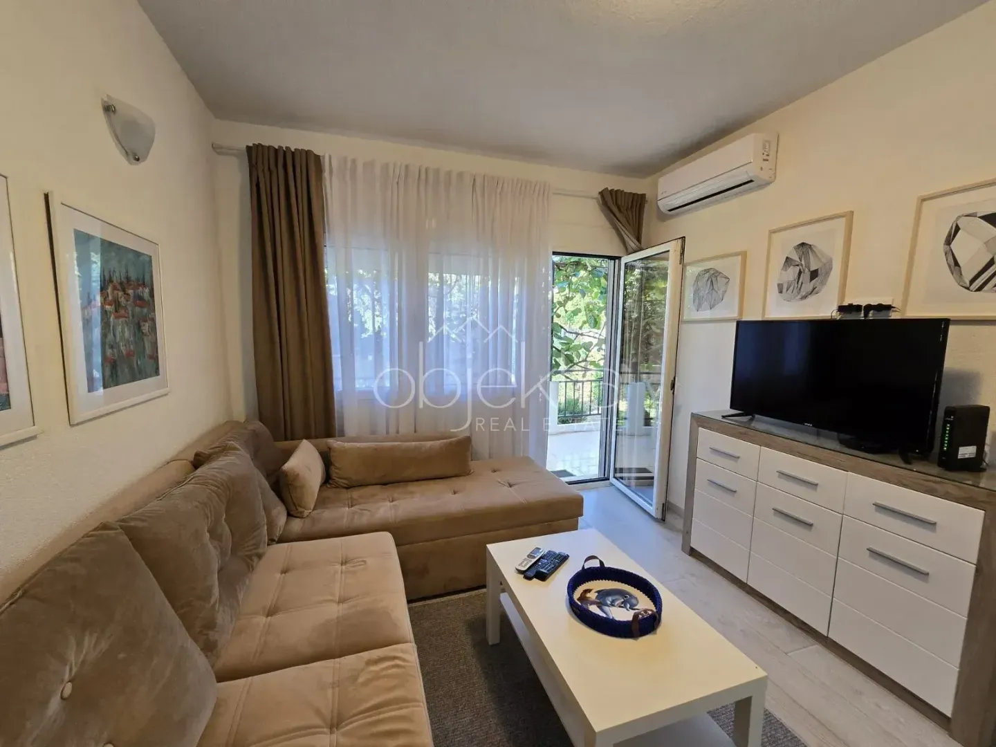 Living room with sofa, TV and access to the terrace.