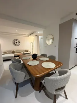 Spacious dining area with a wooden table and grey chairs, connected to the living room. - image 2