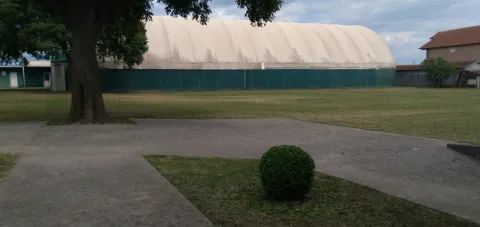 Prostrano dvorište sa popločanim stazama i velikim balonom za sport u pozadini. - image 6