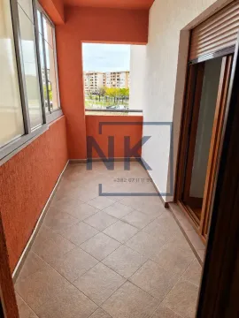 Natskriveni balkon sa popločanim podom i pogledom na grad. - image 5