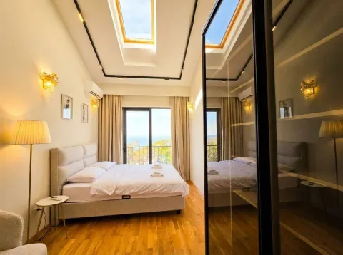 Bedroom with a double bed, skylights, and a balcony with a sea view. - image 11