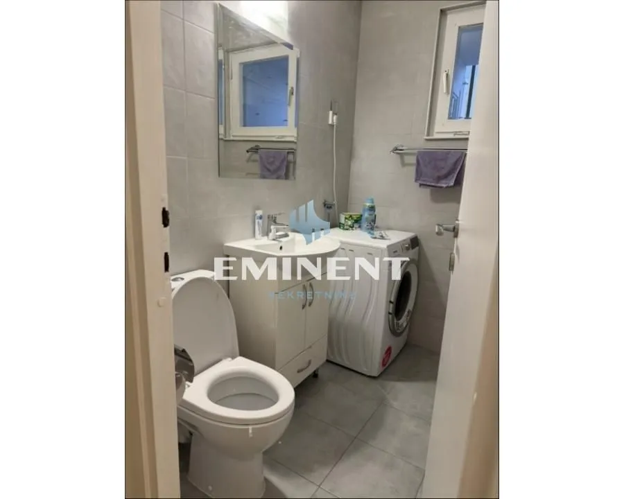 Small bathroom with a sink, toilet, and washing machine.