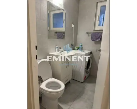 Small bathroom with a sink, toilet, and washing machine. - image 9