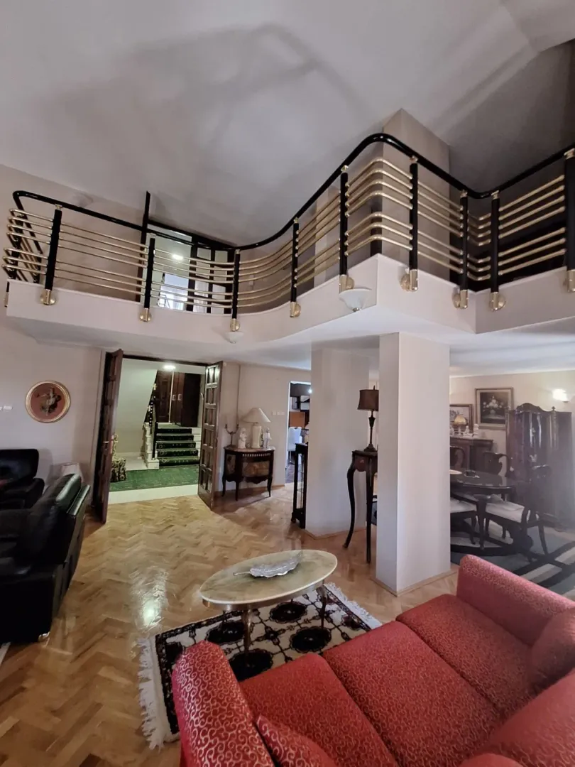 Spacious living room with a gallery and parquet flooring.